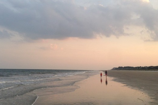 a group of people on a beach near a body of water